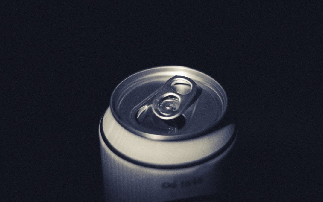 Open beer can against a black background