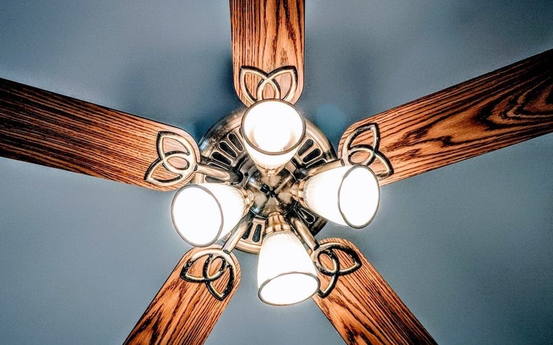 An upwards shot of a ceiling fan.